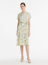 a lady in light green mulberry silk v-neck top with floral printed midi skirt